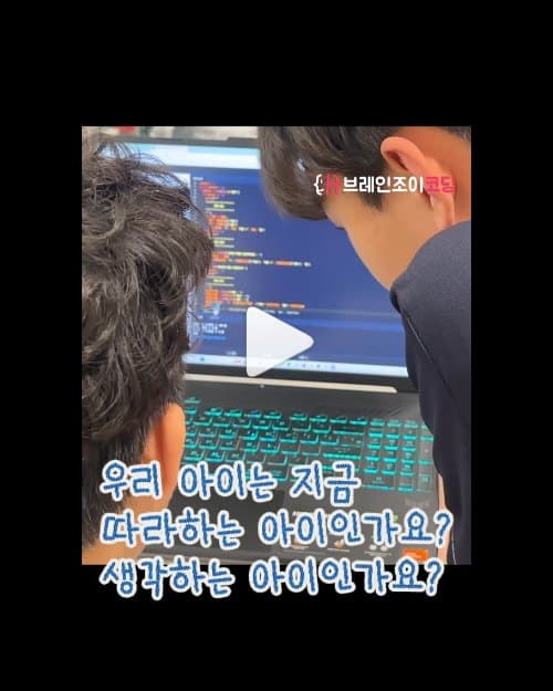노트북 화면의 파이게임 코드를 함께 살펴보는 학생들